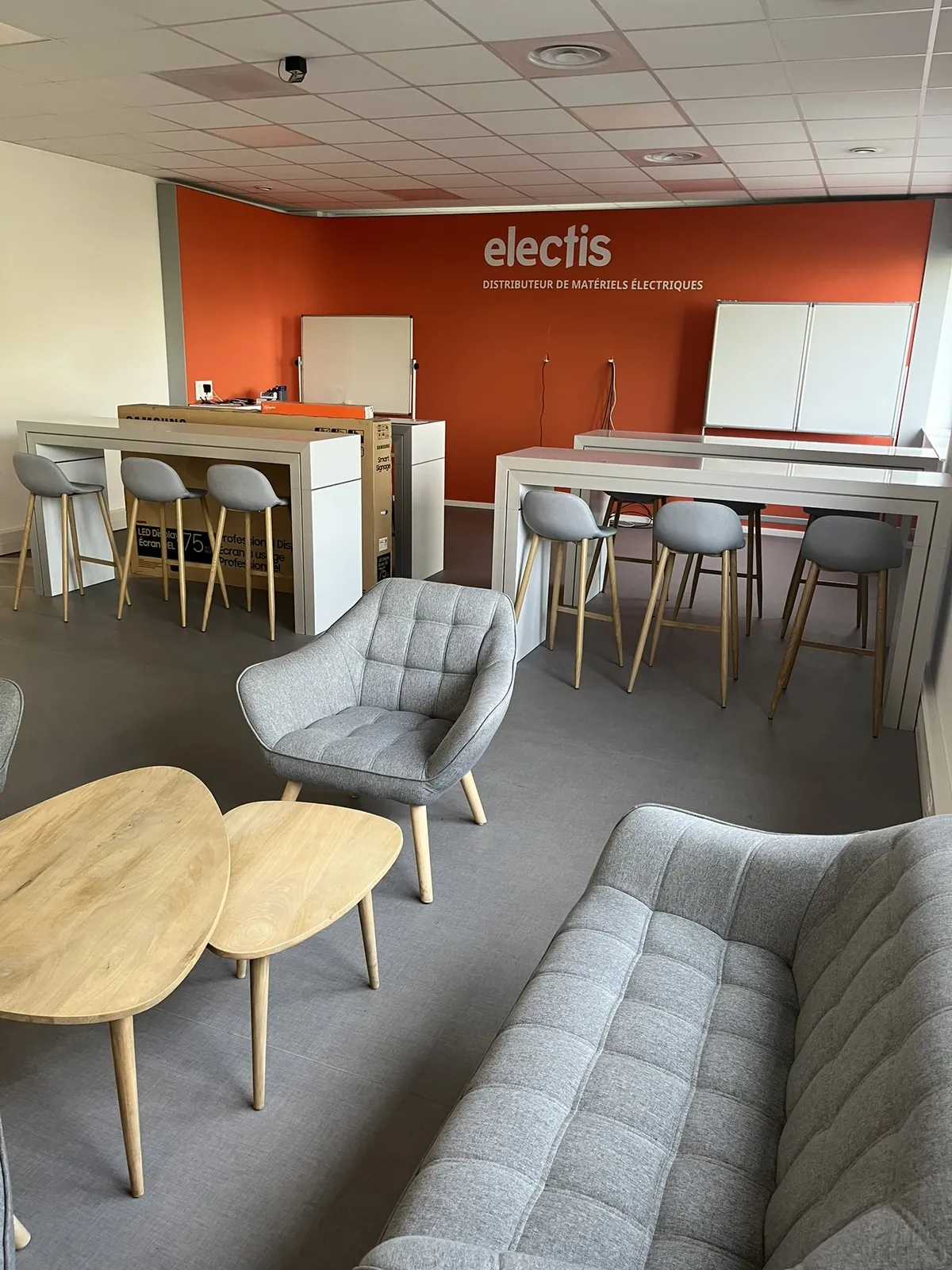 Lot n°72 - Salle de formation : Ecran LED SAMSUNG Display 75 /189,3 cm, 2 armoires basses métal, 4 tables hautes, 12 tabouret tissu, 2 mange debout, 2 canapé, 2fauteuils, 1 table basse, 2 tableaux blancs, Réfrigérateur COMFEE (Site Electis de Lesquin, 264 rue de la Haie Plouvier Commissaires de Justice : SCP ROY LEMOINE GALY 13 rue Haddock - 59 650 Villeneuve d’Ascq)