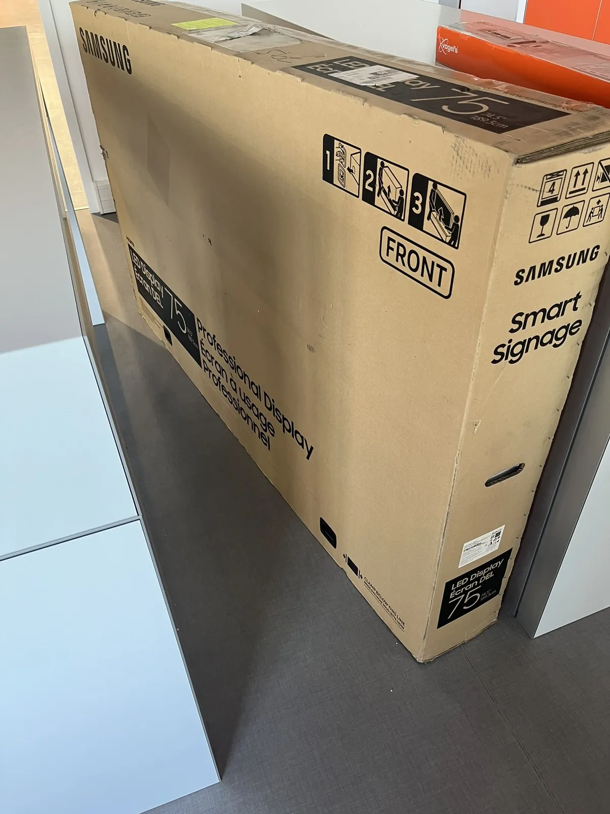 Lot n°72 - Salle de formation : Ecran LED SAMSUNG Display 75 /189,3 cm, 2 armoires basses métal, 4 tables hautes, 12 tabouret tissu, 2 mange debout, 2 canapé, 2fauteuils, 1 table basse, 2 tableaux blancs, Réfrigérateur COMFEE (Site Electis de Lesquin, 264 rue de la Haie Plouvier Commissaires de Justice : SCP ROY LEMOINE GALY 13 rue Haddock - 59 650 Villeneuve d’Ascq)